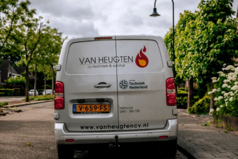 Achterkant van de bedrijfsbus van Van Heugten in een straat